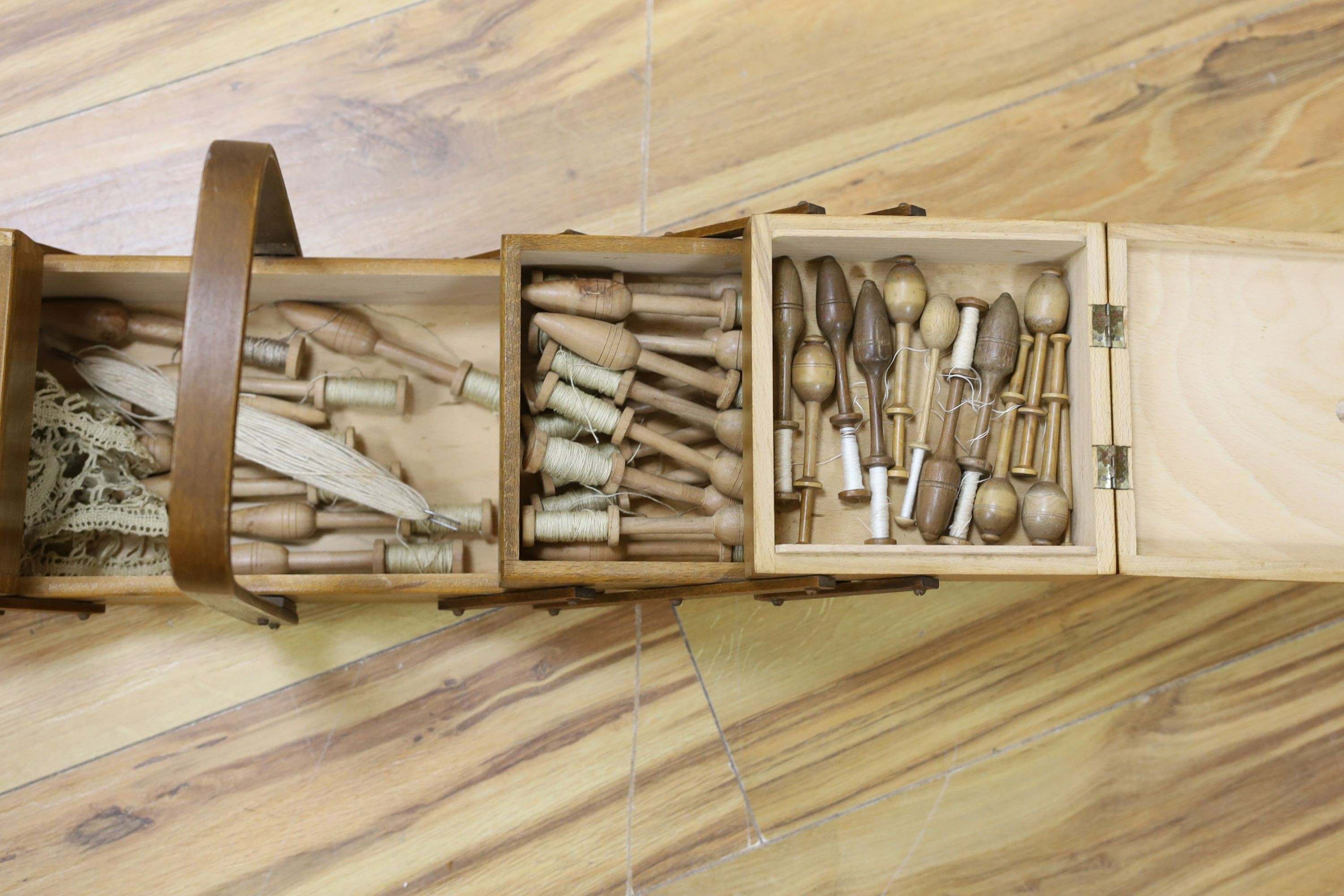 A collection of lace maker's bobbins, cast silver lace-maker under glass dome, related copper wall plate, figures and prints